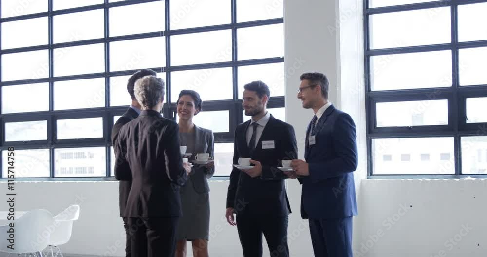 Business people drinking coffee standing in workplace Business people drinking coffee standing in workplace
