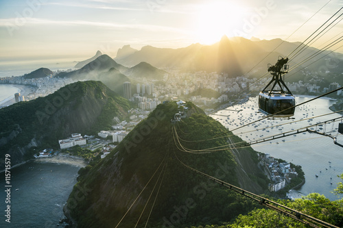 Bright misty view of the city skyline of Rio de Janeiro, Brazil with a Sugarloaf (Pao de Acucar) Mountain cable car passing in the foreground