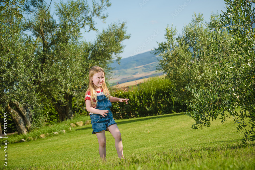 Summer play small beautiful blond girl on green grass Summer play small beautiful blond girl on green grass