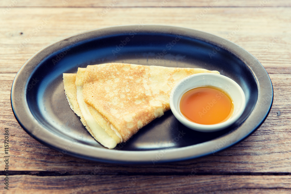 close up of pancakes and honey or jam on plate close up of pancakes and honey or jam on plate