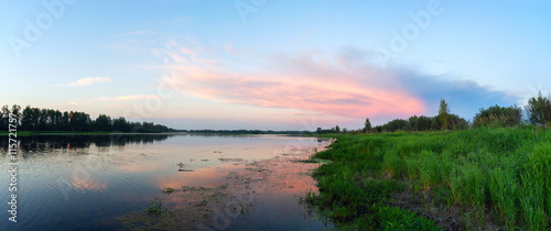 Pink clouds over a lake at sunset .Panorama.