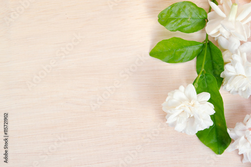 Jasmine flowers spread on wooden board background