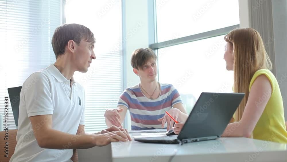 The young people actively talking in the office The young people actively talking in the office
