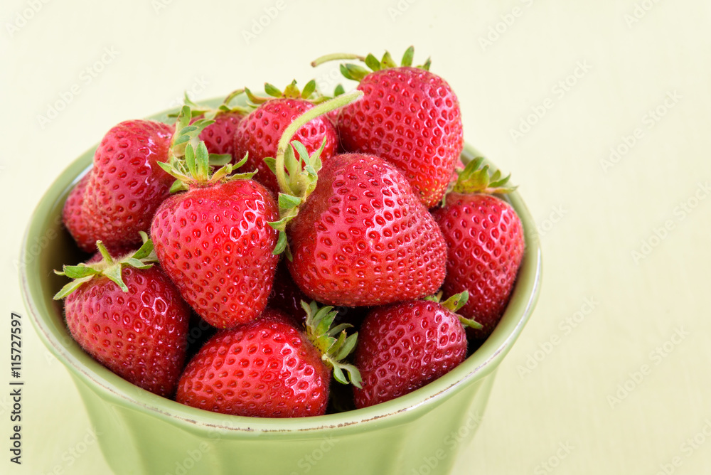 Fresh picked strawberries in a green bowl on a light green background
Fresh picked strawberries in a green bowl on a light green background