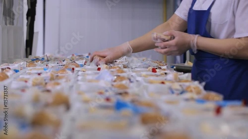 In airport factory the female worker is packing lunch boxes used in airplane