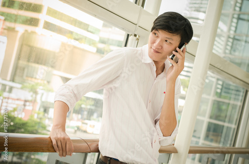 handsome asian man. businessman talking on mobile phone in moder
