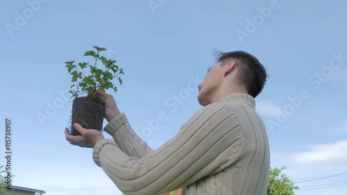 Young guy taking care about plant photo