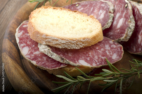 wooden cutting board with salami and bread