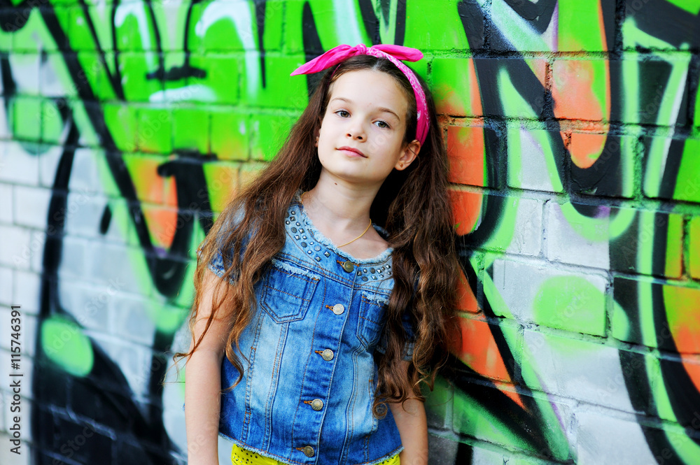 kid girl  near the graffiti wall.