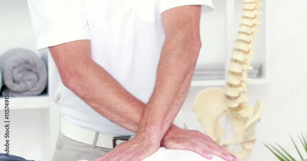 Physiotherapist doing back massage to his patient