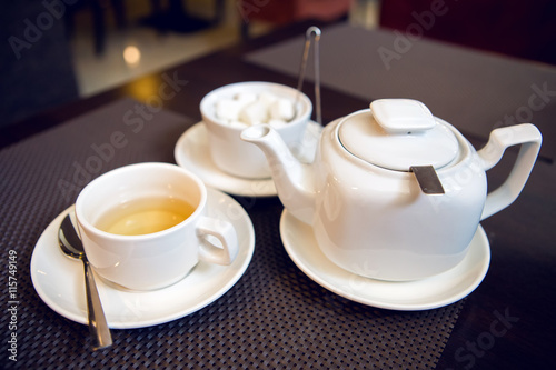 white teapot with tea Cup, saucer and teaspoon