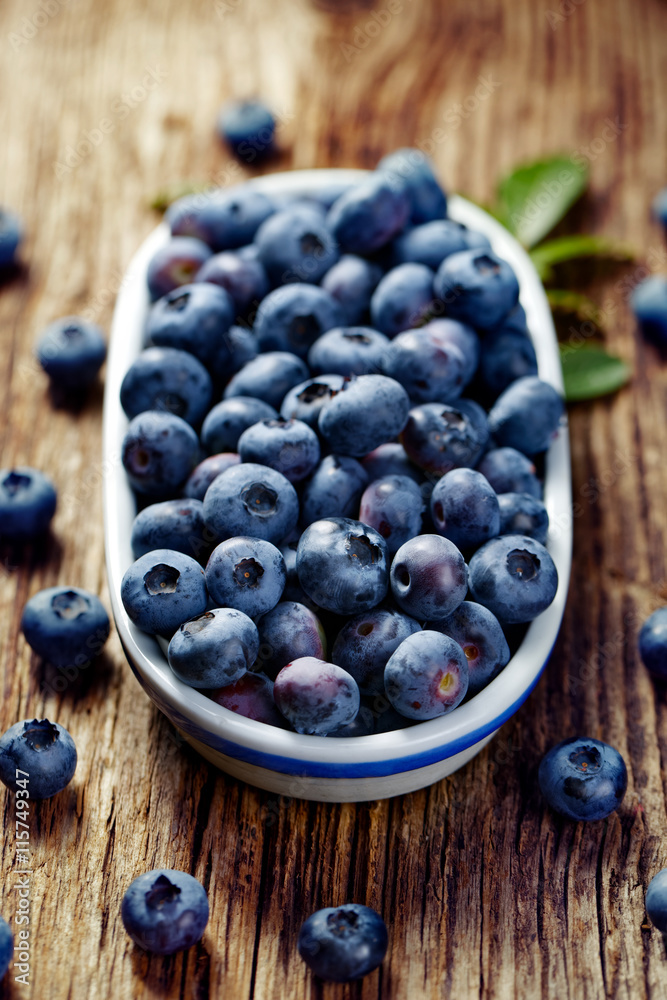 Fresh blueberries from organic cultivation in an oval ceramic pot on a wooden table Fresh blueberries from organic cultivation in an oval ceramic pot on a wooden table