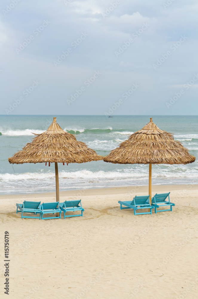 Palm shelters and sun beds in China Beach in Da Nang