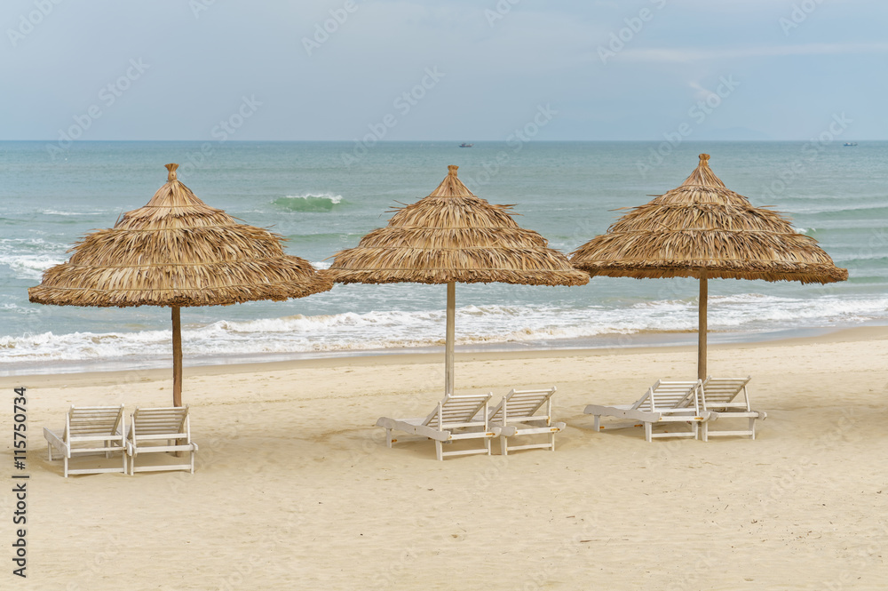 Palm shelters and sunbeds on China Beach in Da Nang