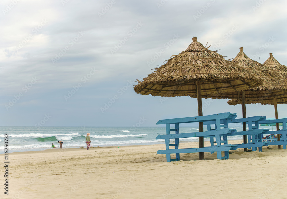 Palm shelters and tourists at China Beach of Da Nang