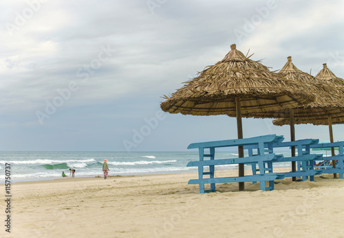 Fototapeta Naklejka Na Ścianę i Meble -  Palm shelters and tourists at China Beach of Da Nang