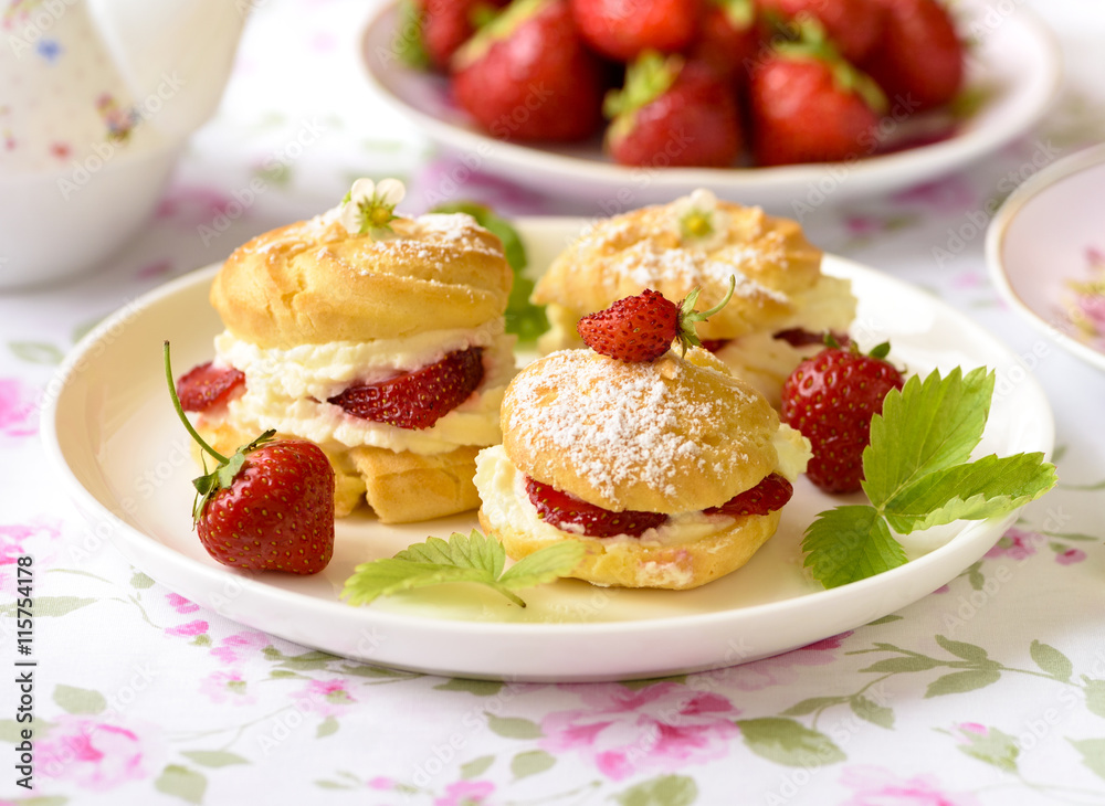 Cream puffs or profiterole filled with whipped cream,g served with strawberries Cream puffs or profiterole filled with whipped cream,g served with strawberries