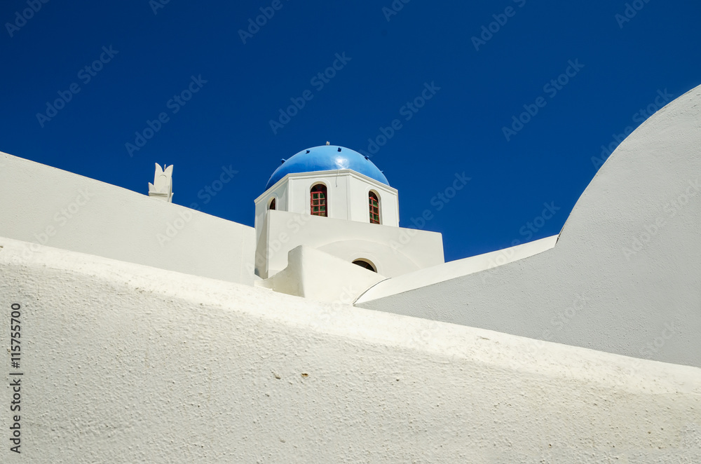 Minimalist view of white chapel with blue dome, Santorini Island in Greece.