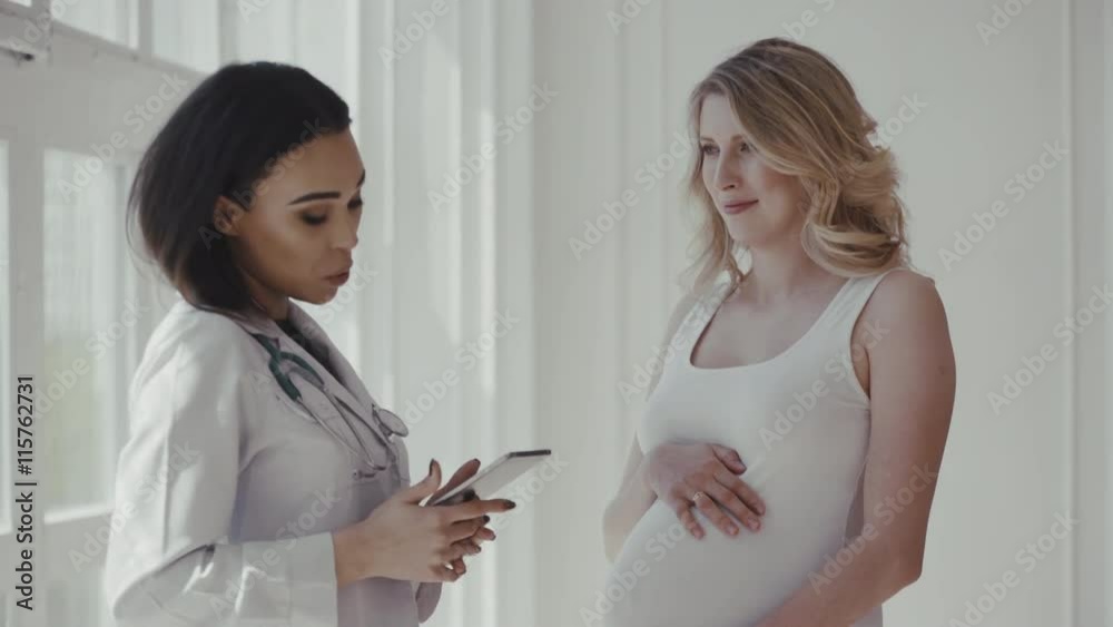 Doctor sharing her notes with pregnant patient Doctor sharing her notes with pregnant patient