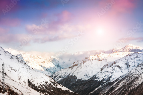 Winter snow-covered mountains at sunset.