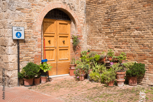 Wooden door with flower pots in the medieval tuscan Town San Gimignano