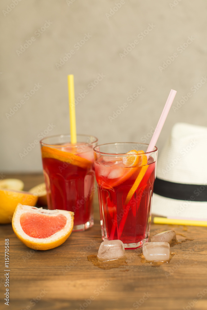 Fototapeta premium two glasses of fruit drink blackcurrant with hat on table