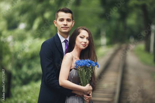 Handsome young couple posing outdoors after ceremony