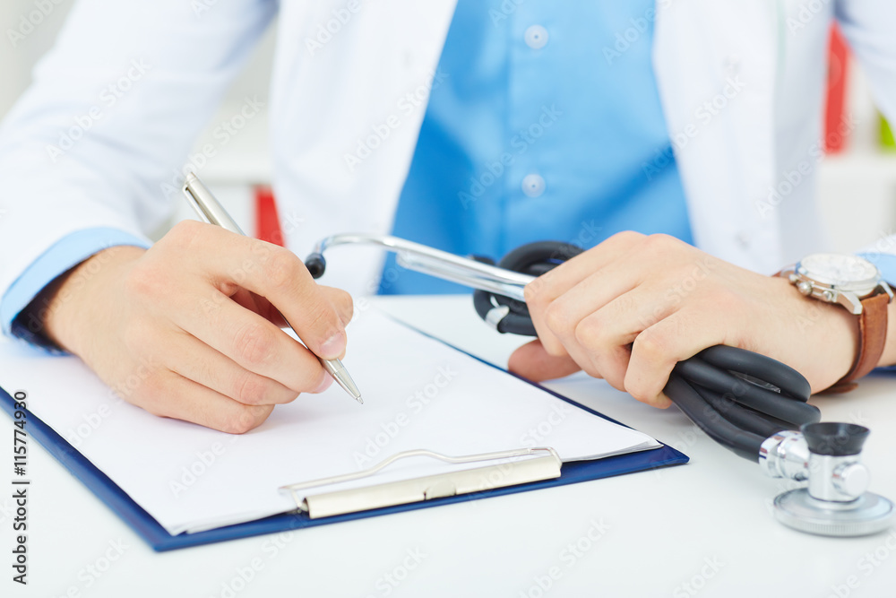 Male medicine doctor hand holding silver pen writing something on clipboard closeup. Ward round, patient visit check, medical calculation and statistics concept. Physician ready to examine patient - obrazy, fototapety, plakaty 