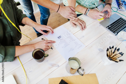 High angle view of business people with paperwork at table in office photo