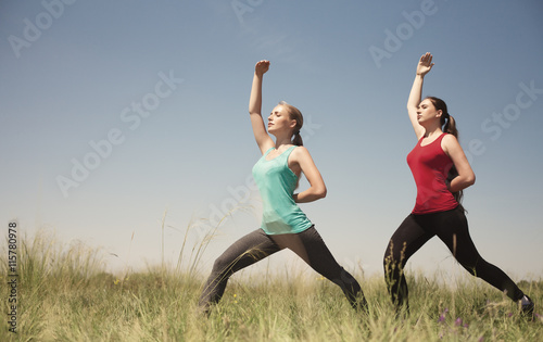 Young two women doing yoga outdoors photo stay and shows poses