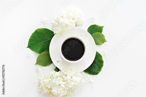cup of coffee with flowers on table