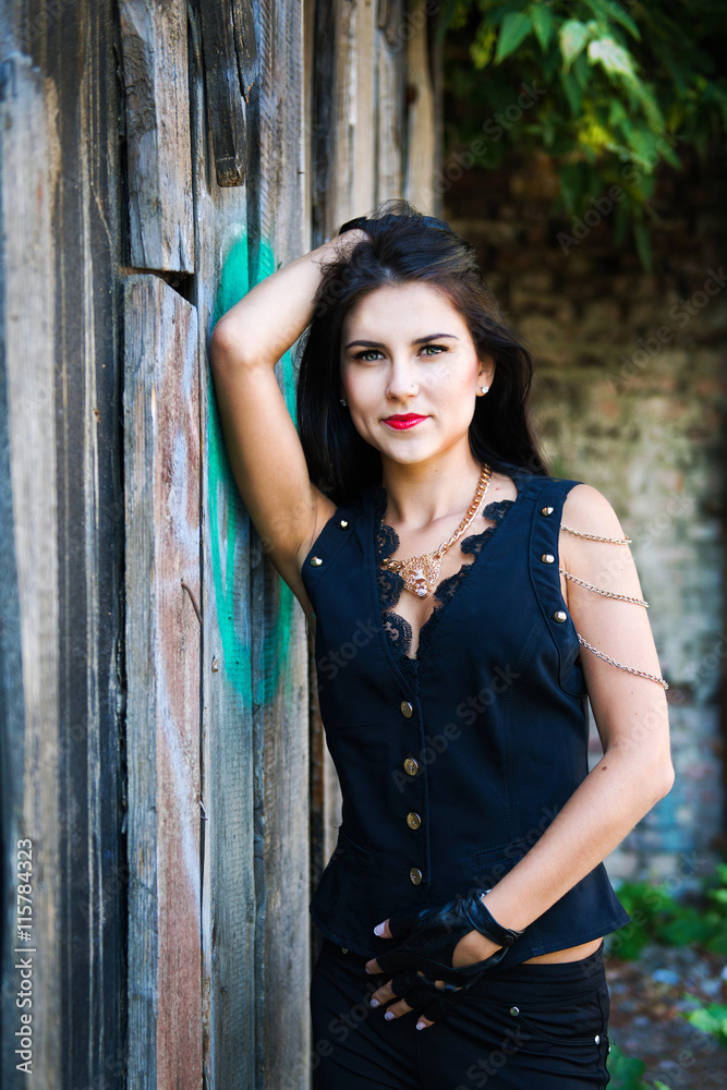 Fototapeta premium Pretty young woman near wooden wall