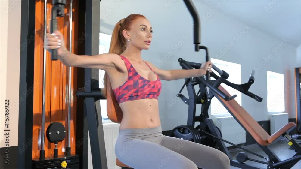 Woman makes a butterfly exercise at the fitness centre Woman makes a butterfly exercise at the fitness centre