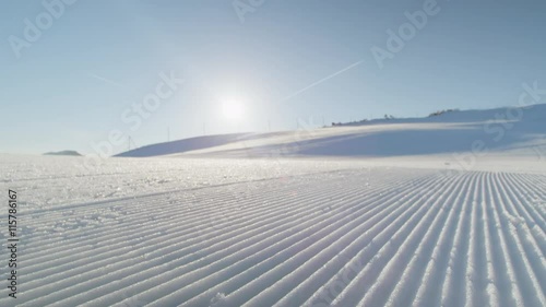 CLOSE UP: Perfectly groomed  piste snow in sunny ski resort 