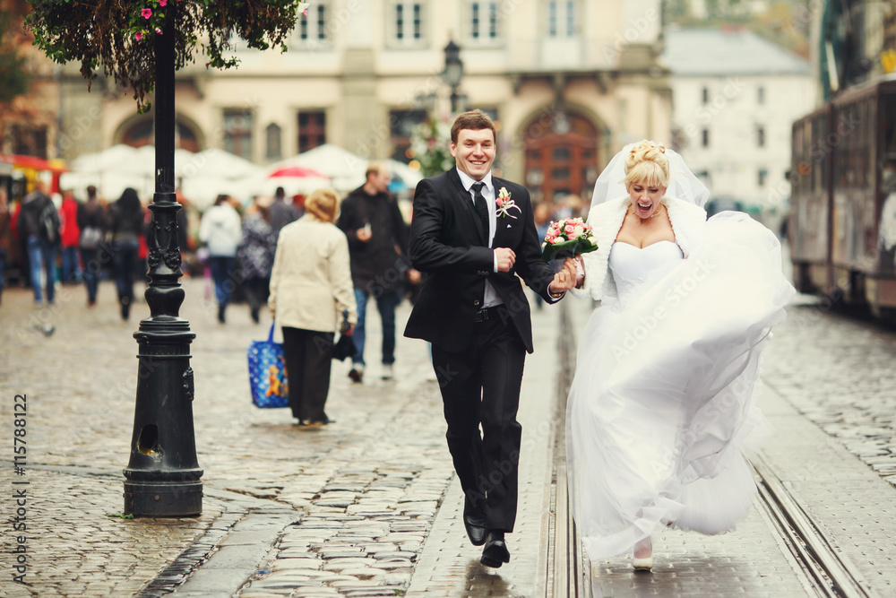 Bride screams while running along the tramways with a groom Bride screams while running along the tramways with a groom