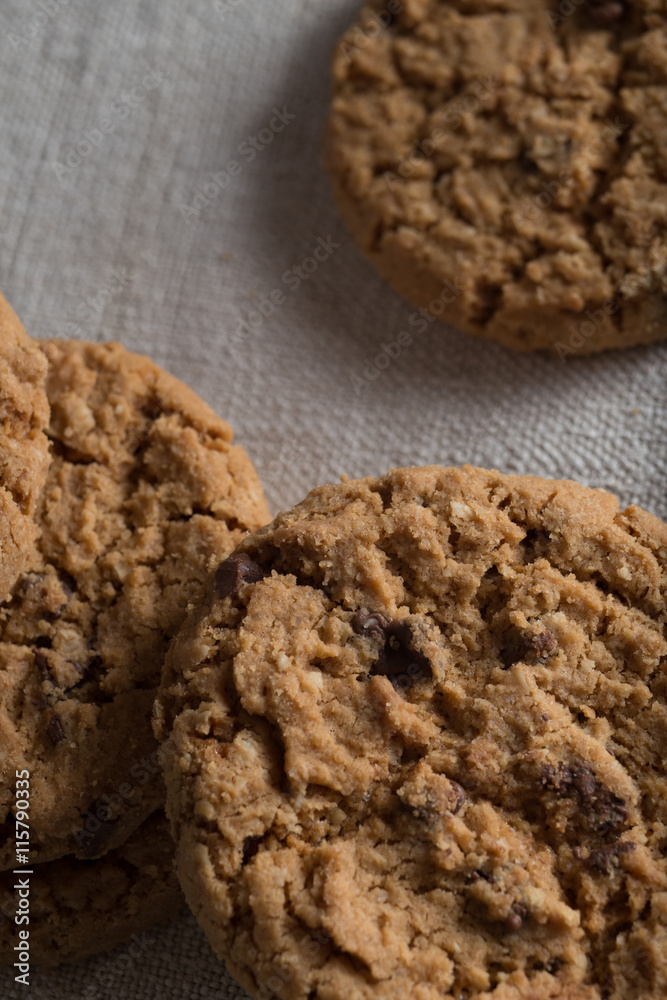 Cookies pile with chocolate chip on light textile background. Delicious morning snacks for breakfast, brunch and lunch. Appetizing, healthy, sweet, scrummy, and fast food. Cookies pile with chocolate chip on light textile background. Delicious morning snacks for breakfast, brunch and lunch. Appetizing, healthy, sweet, scrummy, and fast food.