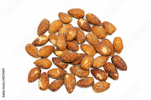 Almonds baking with salt on white background.