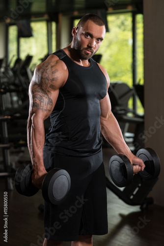 Muscled Male Model Exercising Biceps With Dumbbells