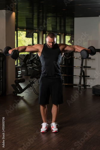 Bodybuilder Exercise Shoulders With Dumbbells
