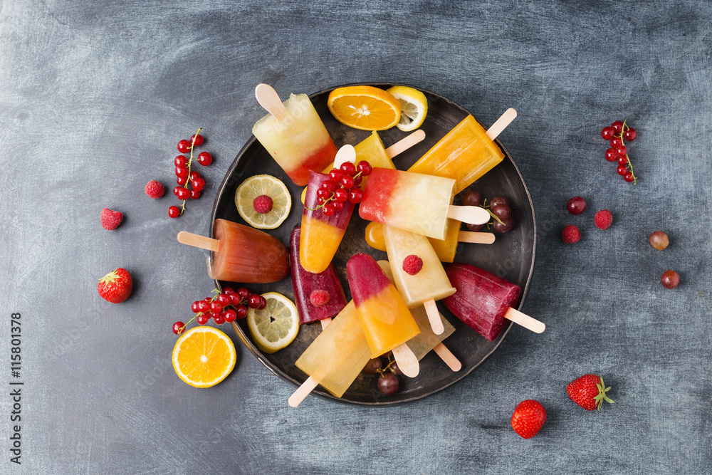 Fruits and different homemade ice lollies made of fruit juice and pulp