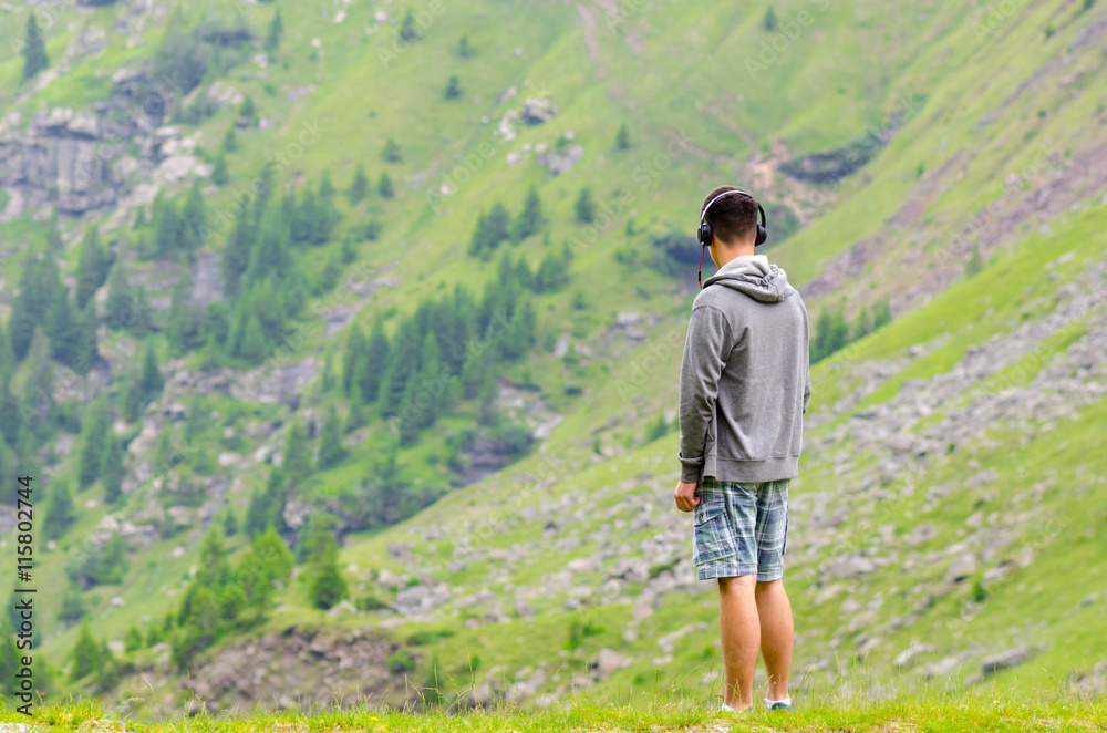 Naklejka premium Teenager man with headphones watching the mountains melacholic