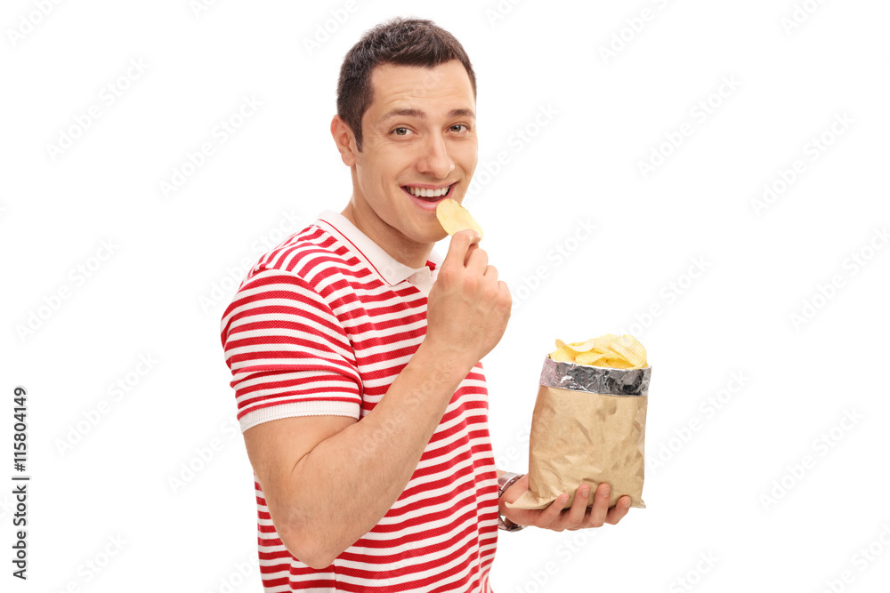 Young cheerful guy eating potato chips Young cheerful guy eating potato chips