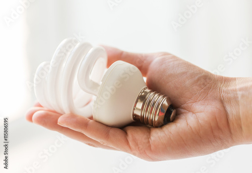 close up of hand holding energy saving lightbulb