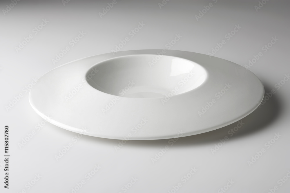 White round plate with a special design on a white table White round plate with a special design on a white table