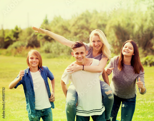 Teenagers running on green lawn in park . © JackF