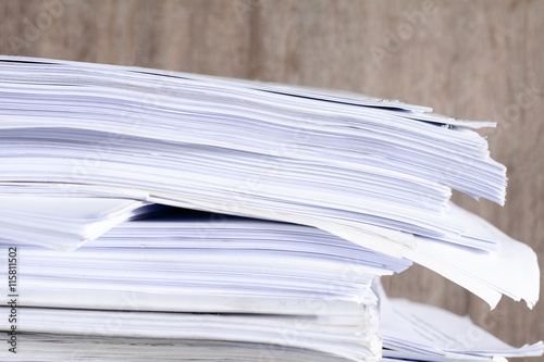 Stack of business report paper files on desk