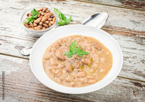 Bean soup in a plate on wooden table