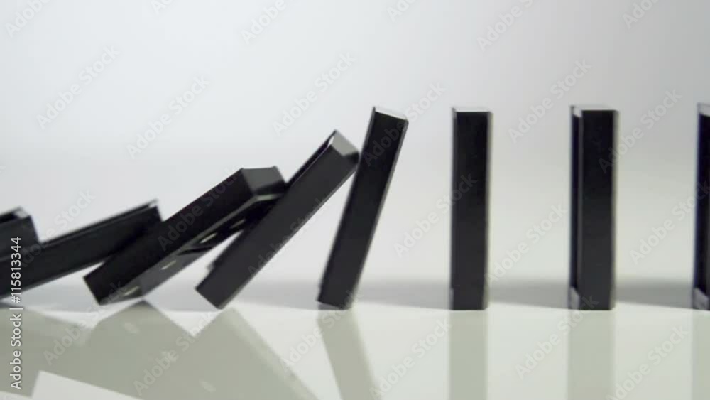 Row of dominoes with one falling over