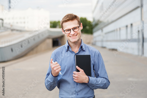 happy man businessman with diary and pen in the hands