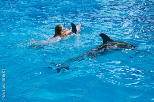 Happy child and dolphins in blue water. Dolphin Assisted Therapy